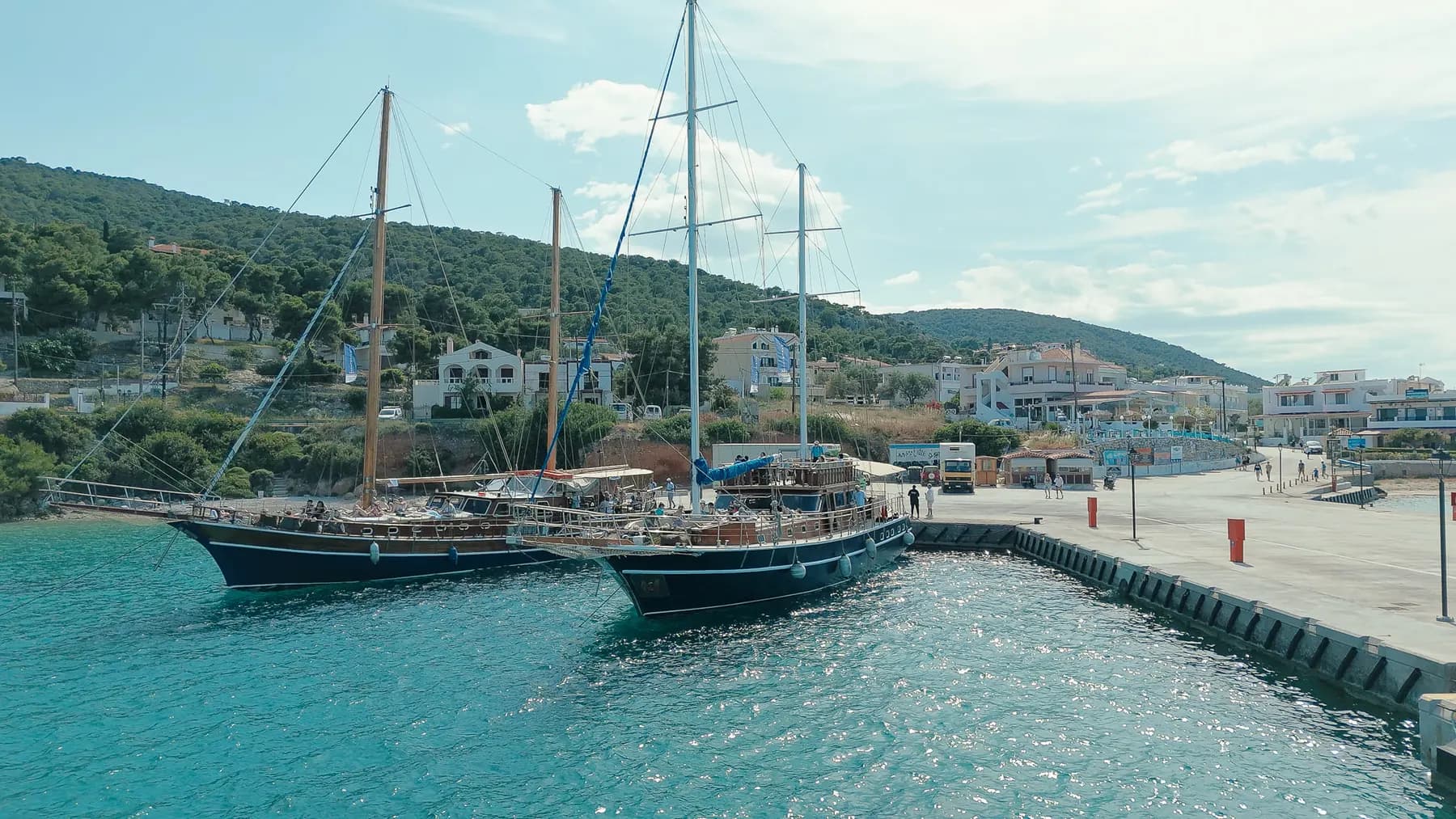 Two gulets moored side by side at a village harbour